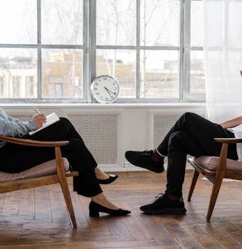 A therapist engaging in a counseling session with a male patient to support mental health.